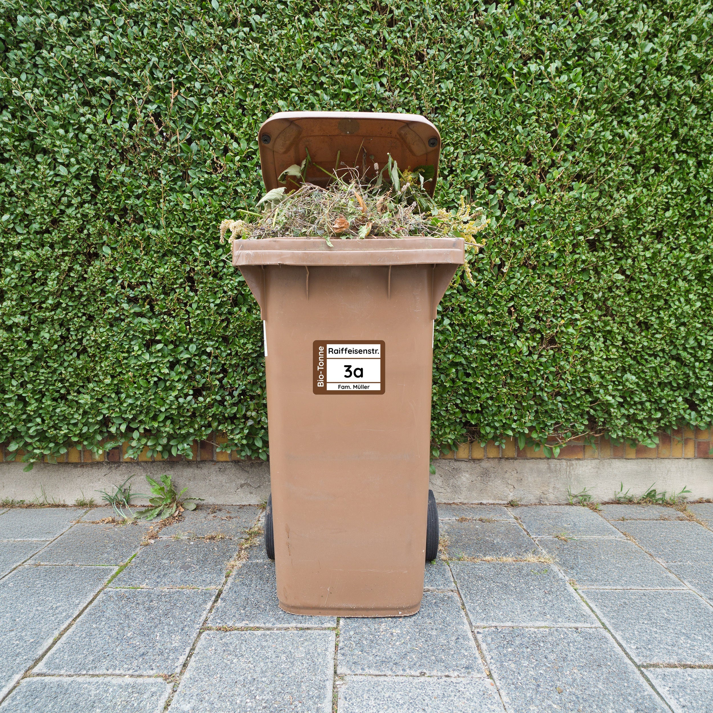 Vier wetterfeste Mülltonnenaufkleber in 19x14 cm, individuell gestaltbar, zeigt personalisierte Recycling- und Abfall-Icons.