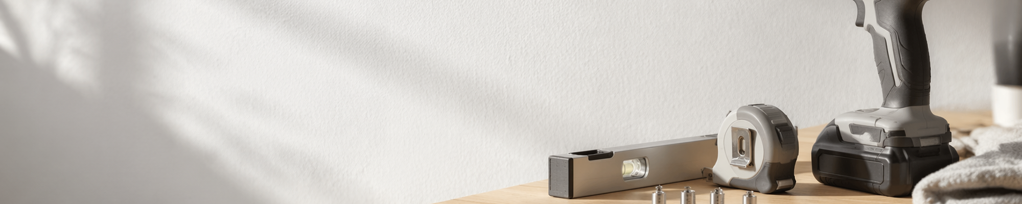 Verschiedene Schilder-Befestigungen wie Abstandshalter, Saugnäpfe und Zierkopfschrauben an einer hellen Wandfläche